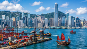 Hong Kong Victoria Harbour skyline with traditional red sailboats and commercial buildings for business incorporation content.