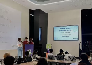 Pam Ros Damarillo delivers a presentation at a DevCon Kids Philippines event, encouraging students to become future tech leaders as attendees watch from the audience.
