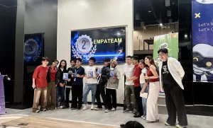 Members of Empateam celebrate their second-place finish at the DevCon Kids AI hackathon, posing for a group photo with organizers and mentors while displaying their prizes and certificates.